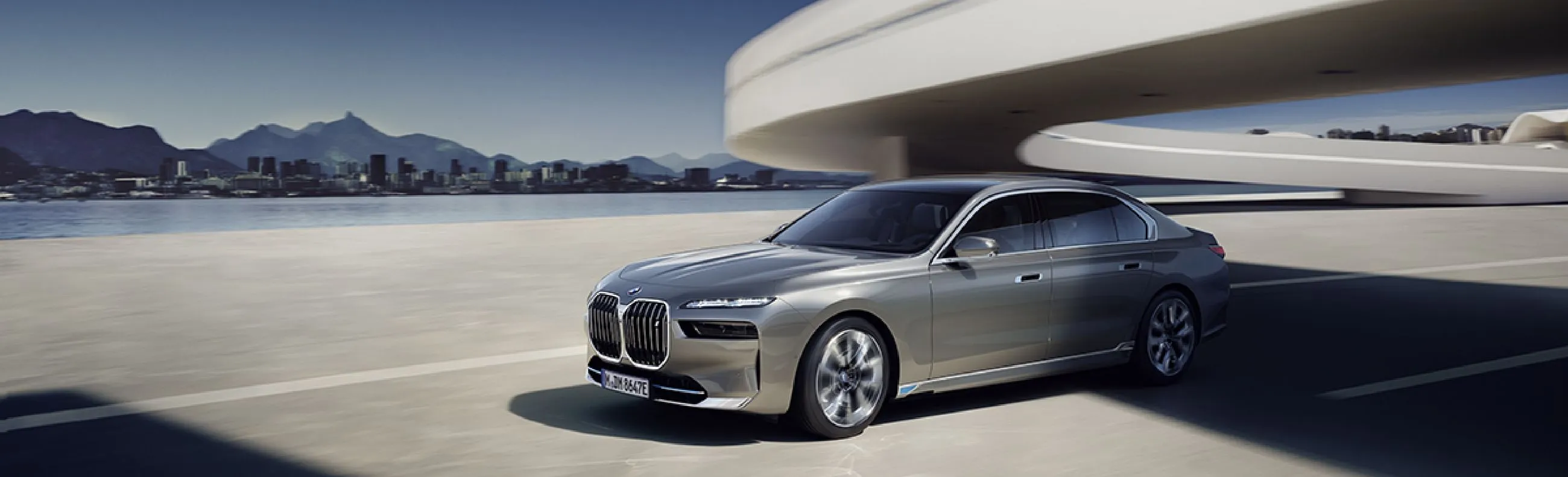 Silver BMW car, passing under a bridge