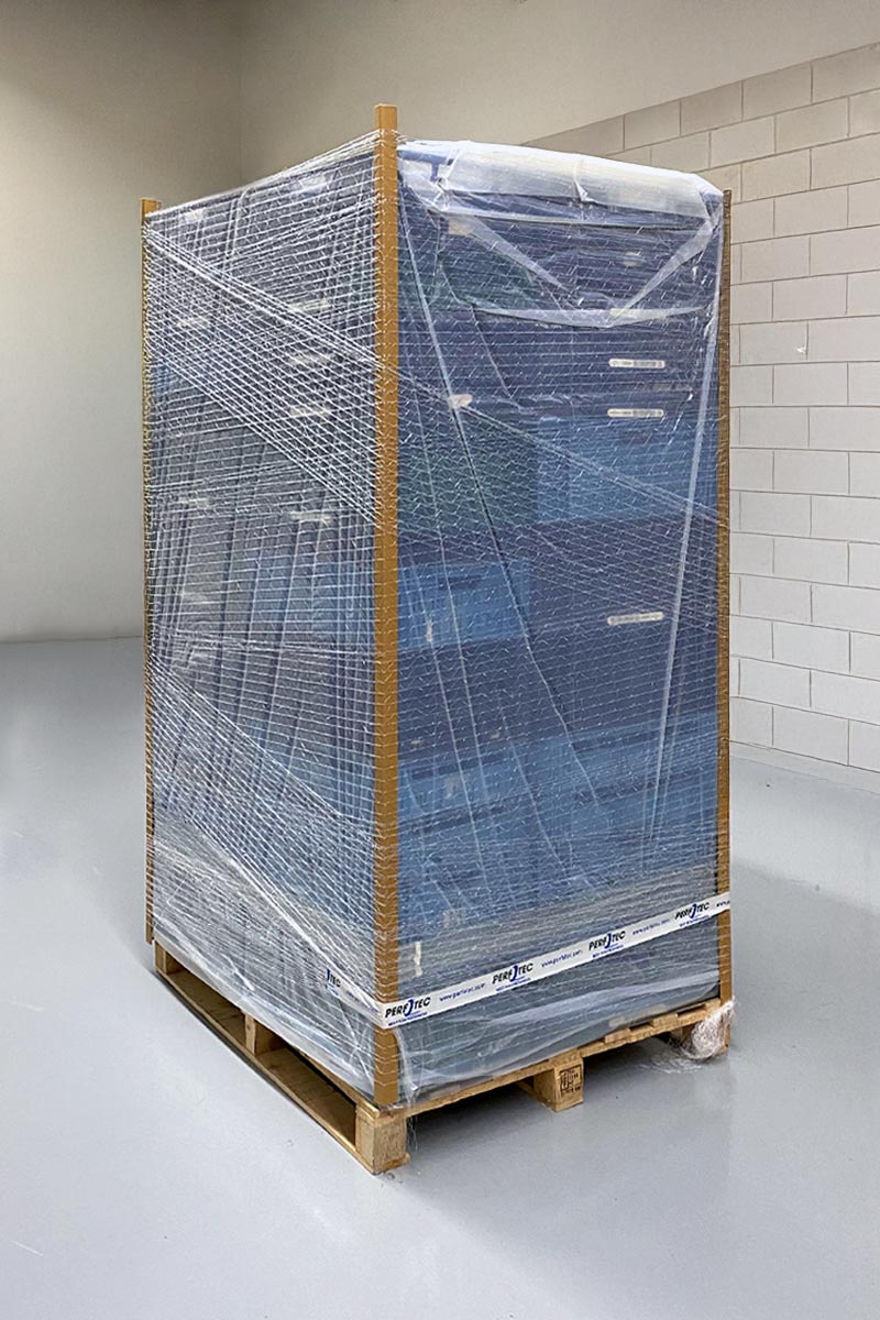 Stacked packs of fresh produce on a wooden pallet wrapped tightly in PerfoTec Pallet Cover.