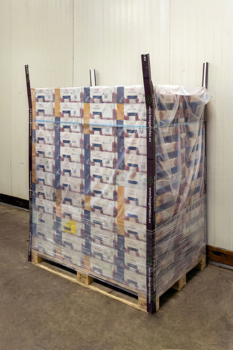 Wooden pallet stacked with multiple boxes wrapped in PerfoTec Pallet Cover.