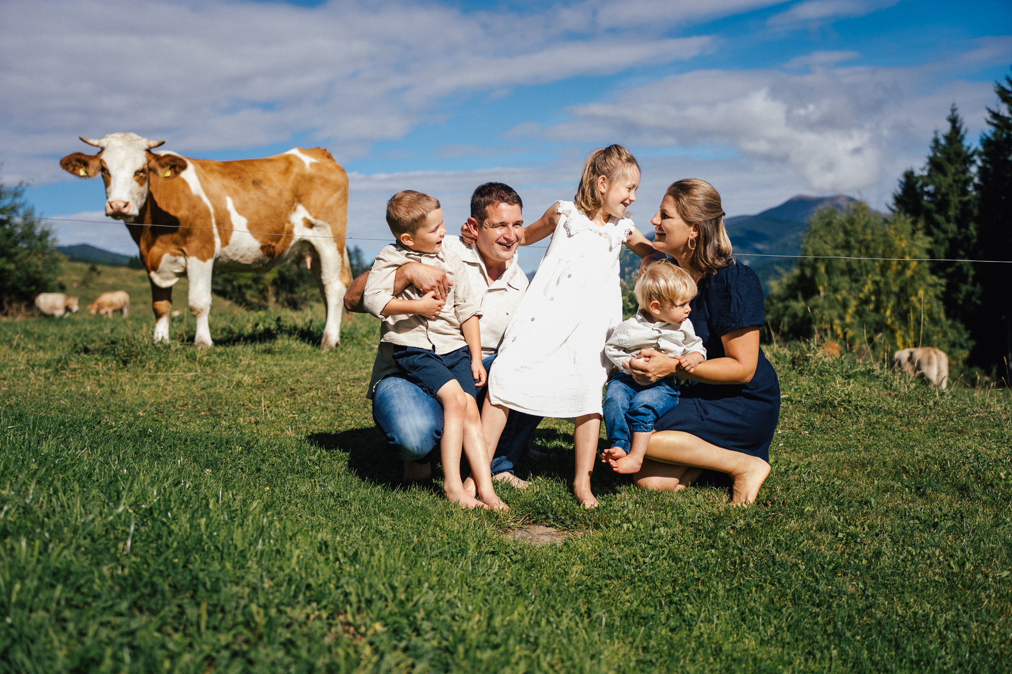 Familienfoto auf der Alm im Sommer in der Steiermark – Eltern mit lachenden Kindern