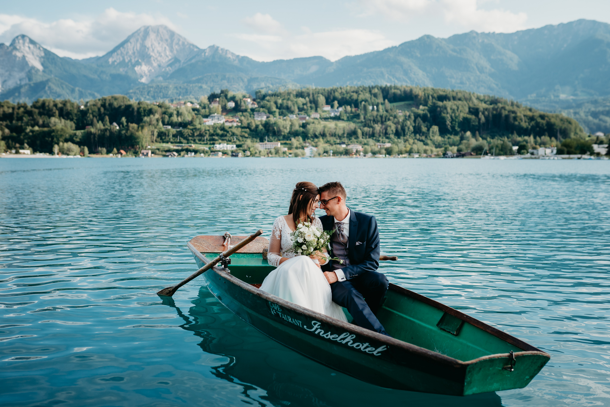 Brautpaar macht eine Bootsfahrt nach der Hochzeit am Faaker See beim Inselhotel