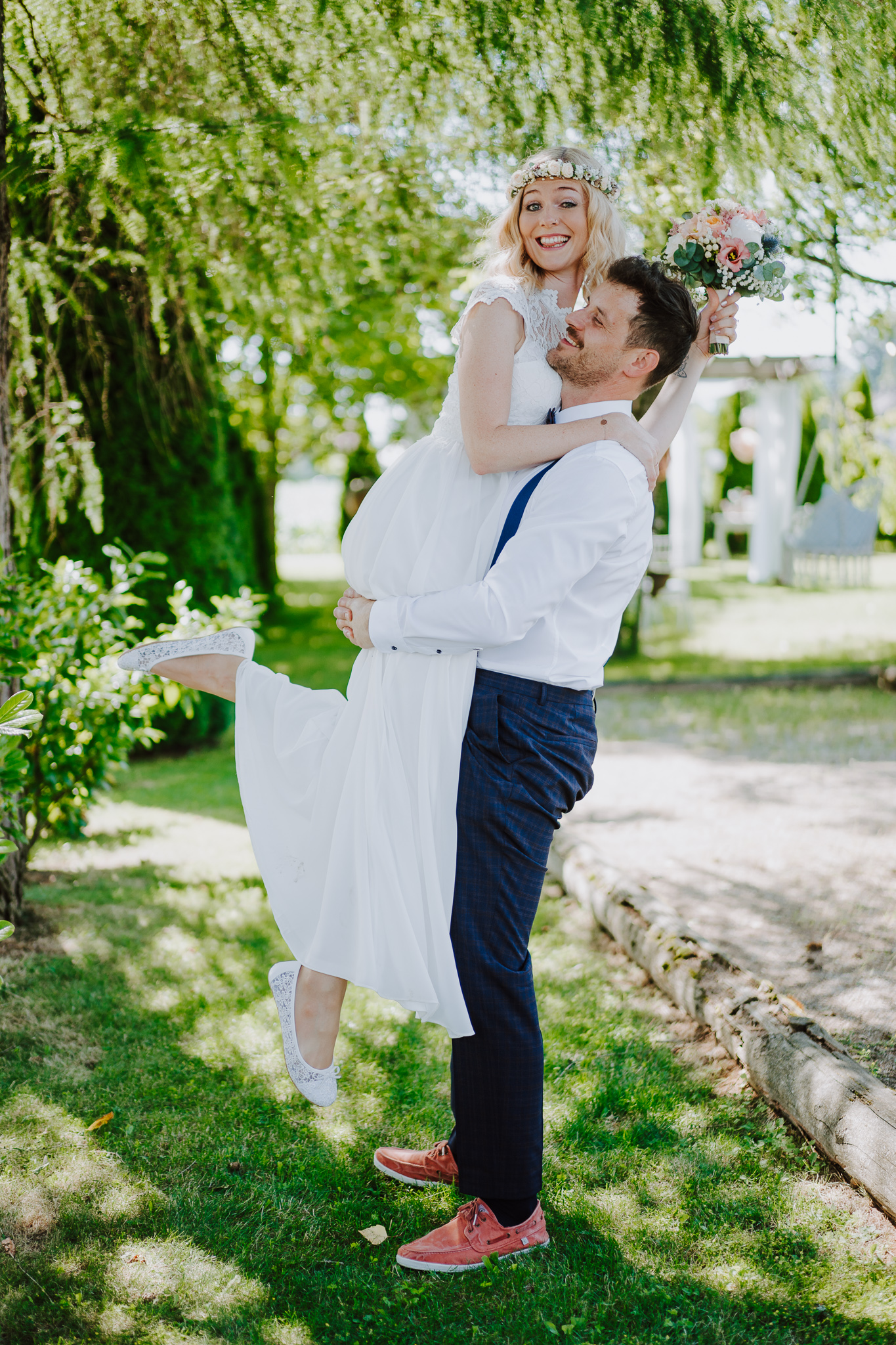 lustiges Foto von Bräutigam, der seine Braut hochhebt