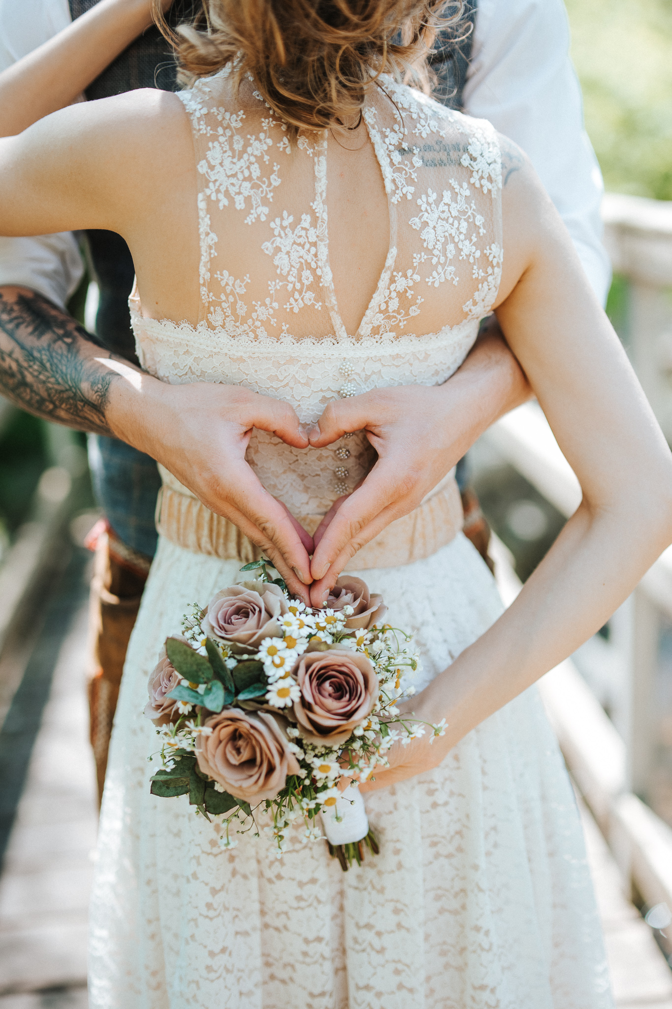 Hände, die ein Herz aus Liebe Formen mit Brautpaar