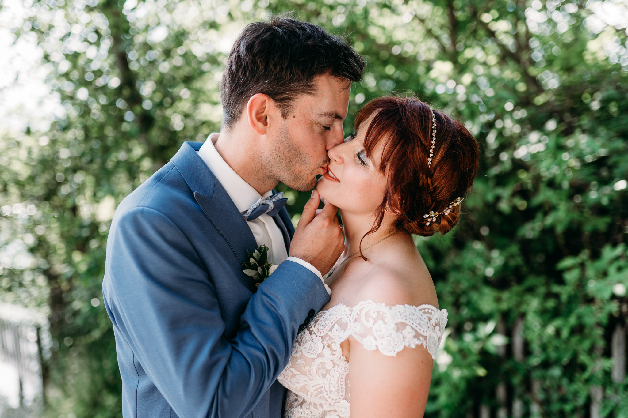 romantischer Hochzeitskuss im Grünen mit weichem Licht
