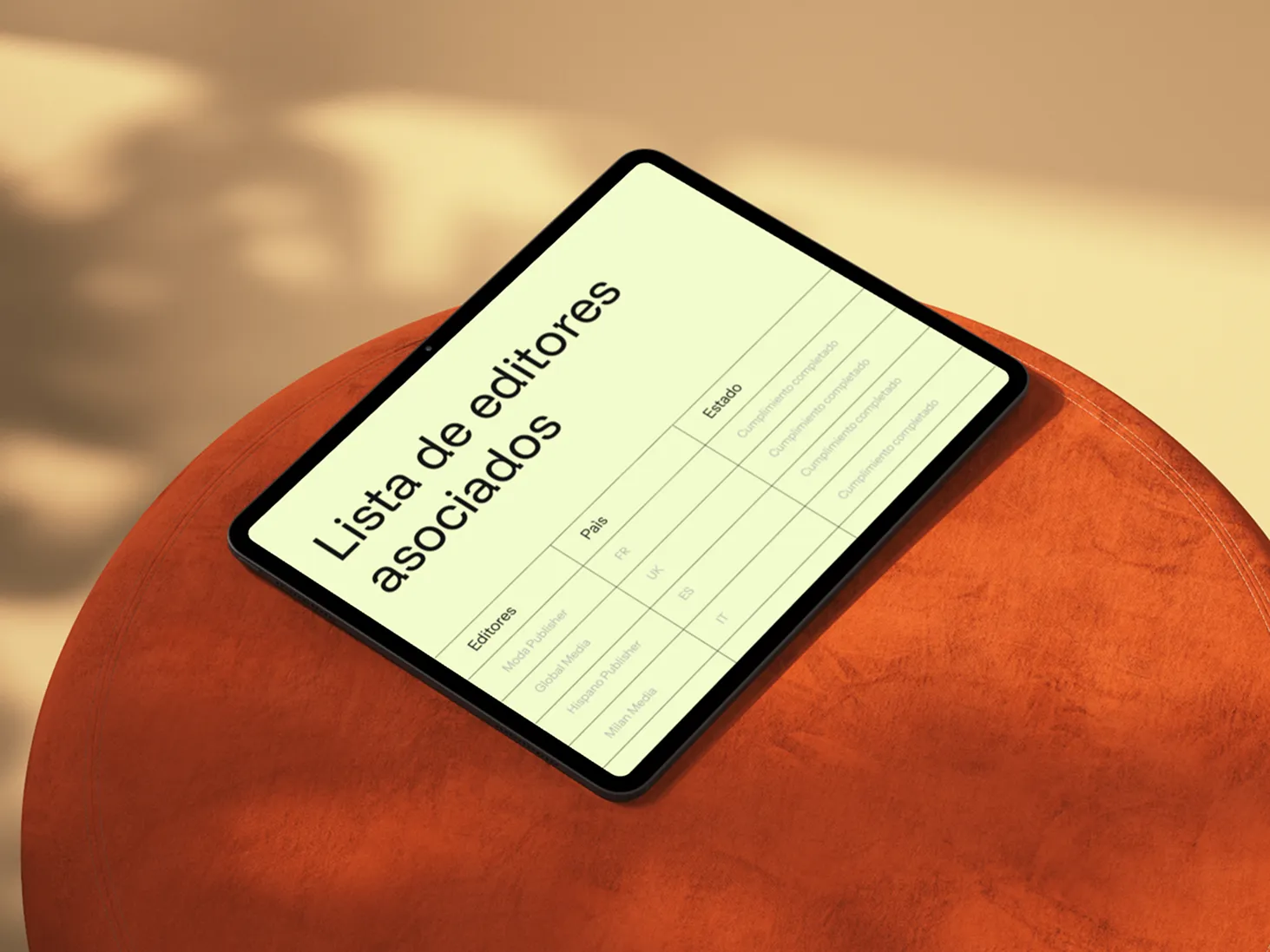 Tablet displaying a list of associated publishers with their country codes and status, placed on an orange round table.