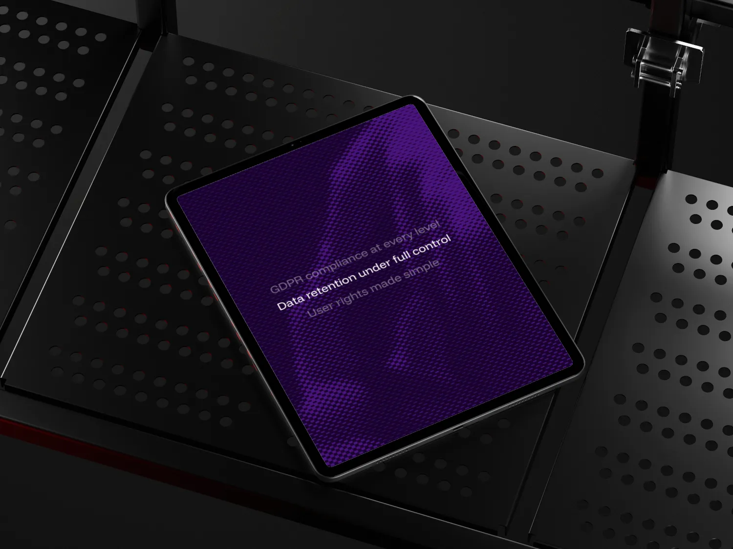 Tablet on perforated black surface displaying text about GDPR compliance and data retention control on a purple background.