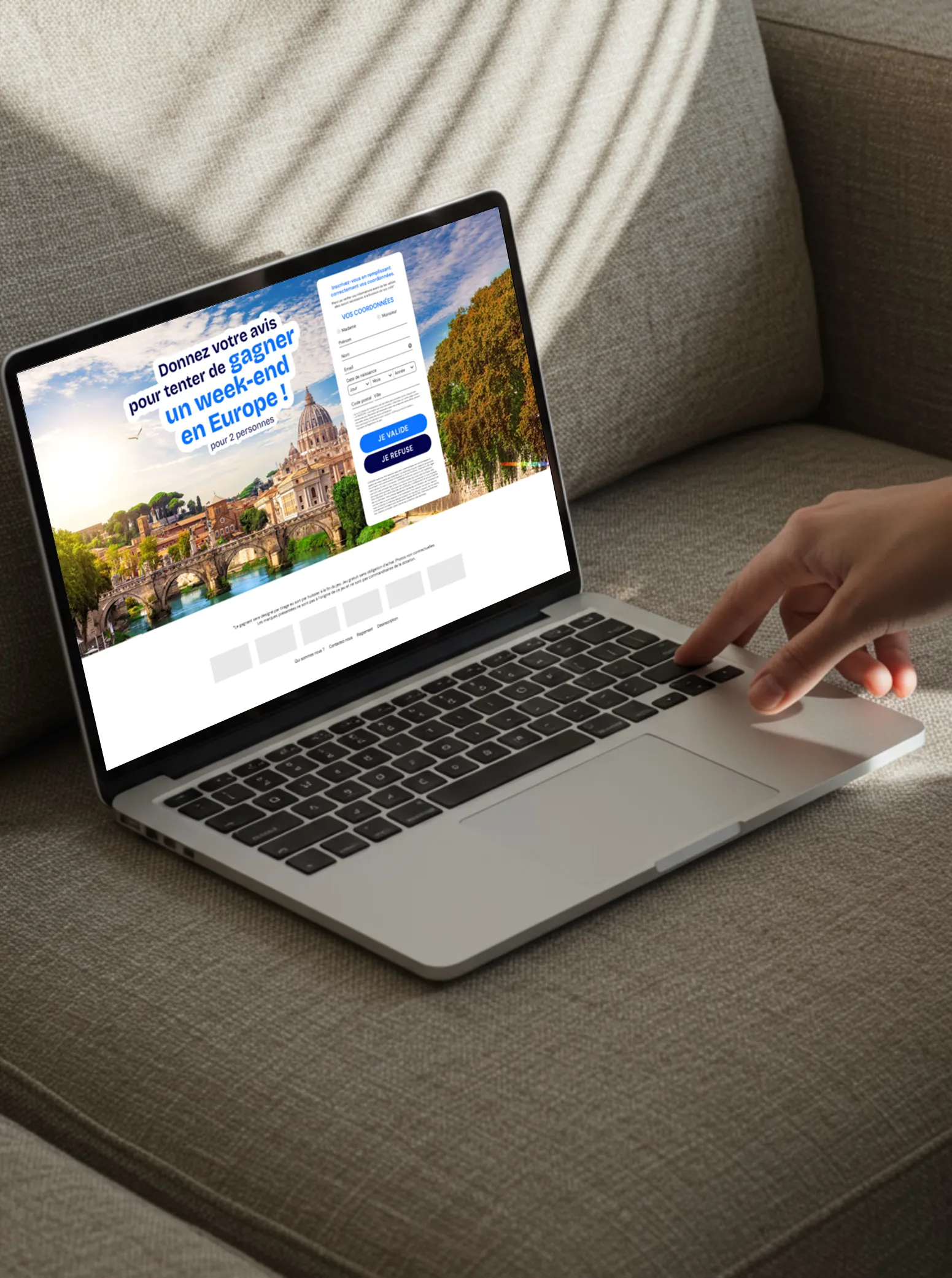 Person using a laptop on a sofa with a contest webpage offering a chance to win a weekend in Europe for two.