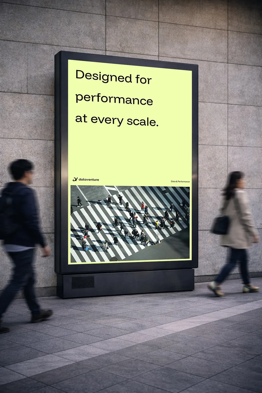 Outdoor digital billboard showing an aerial view of people crossing a large zebra crosswalk with the text 'Designed for performance at every scale.'