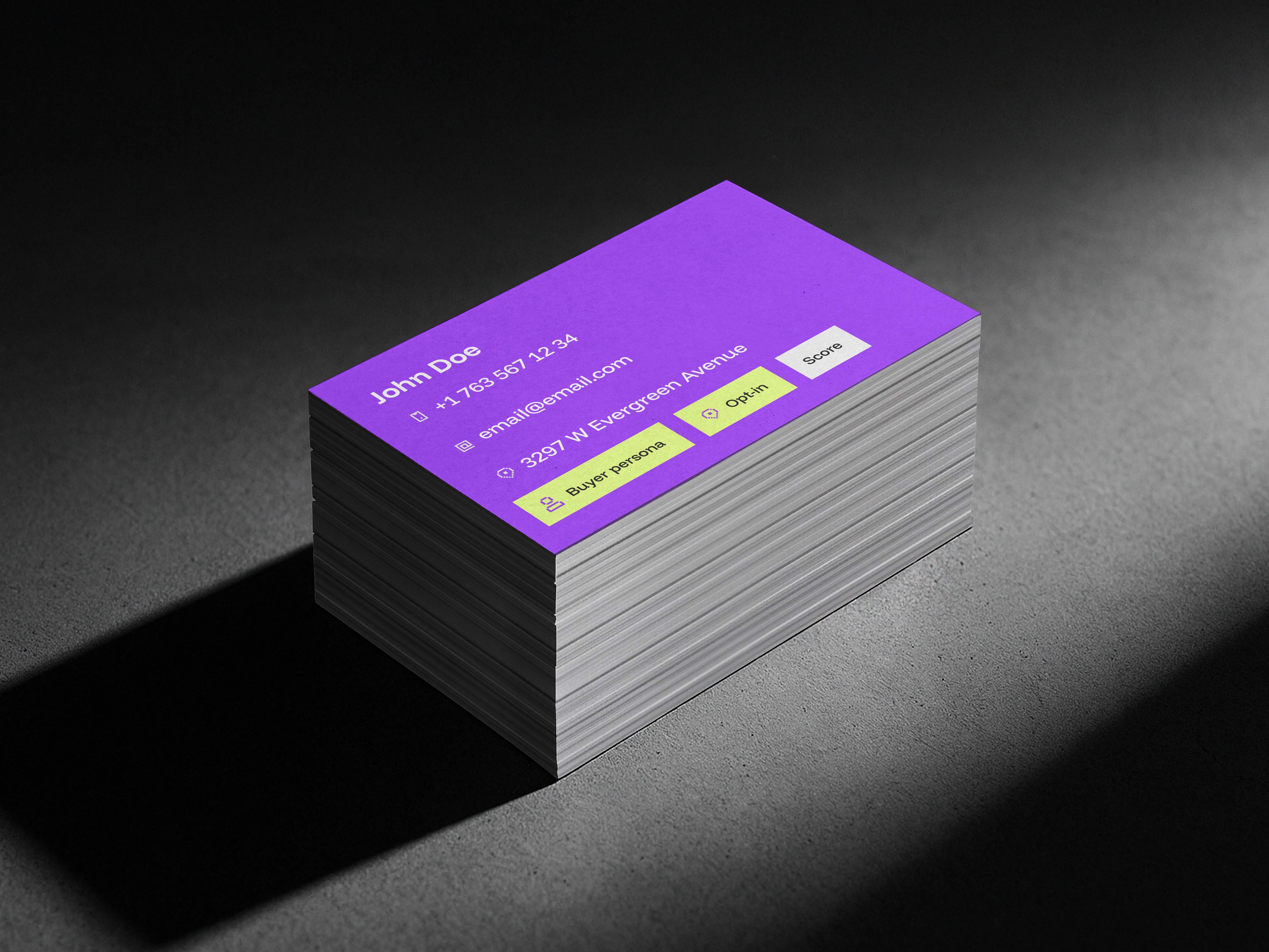 Stack of business cards with purple top card showing contact details for John Doe and buttons labeled Buyer persona, Opt-in, and Score.