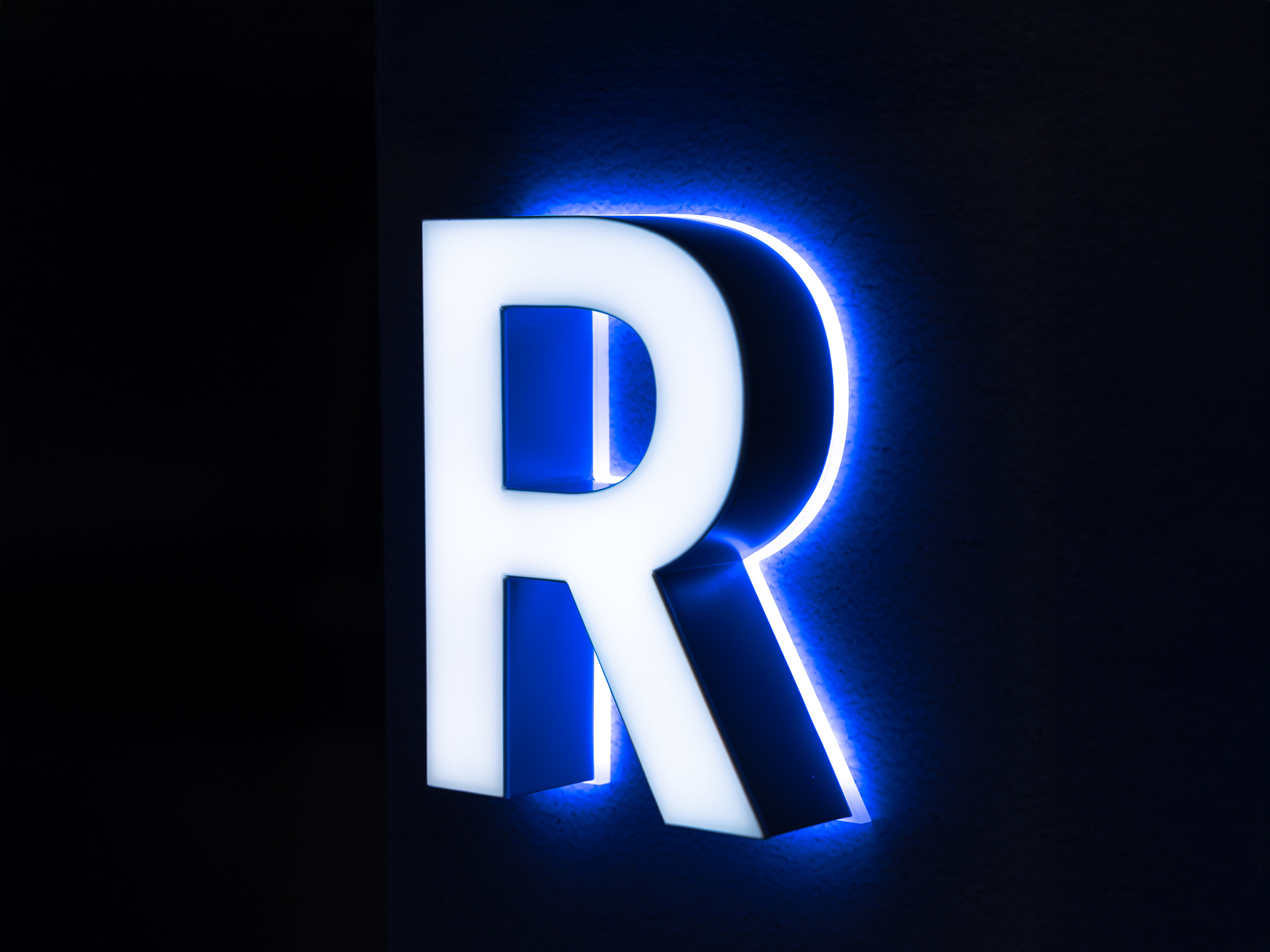 UF1S2 multi-directional face and halo-lit channel letter with white vinyl face and blue halo glow.