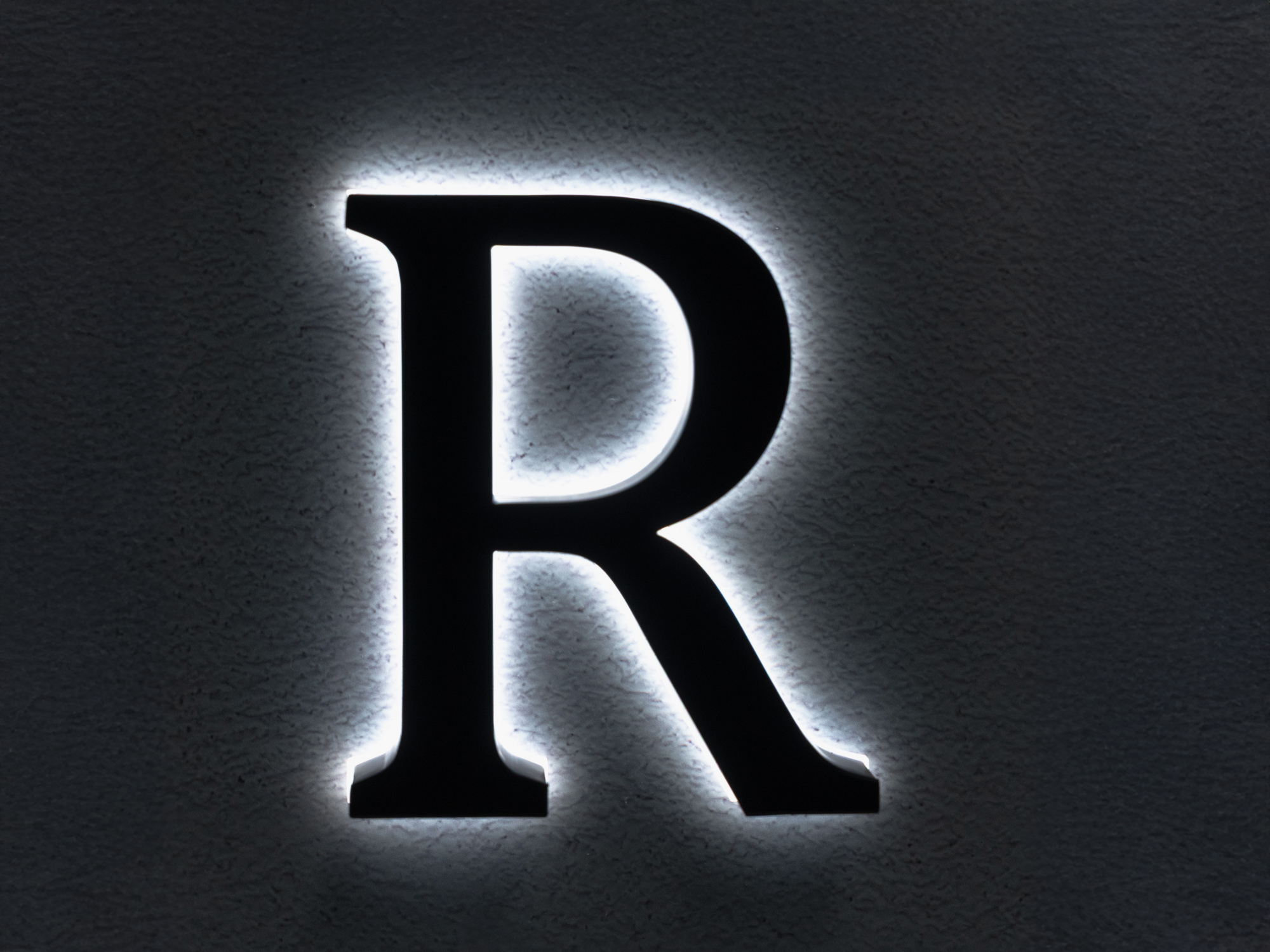 US2 TruTrimless acrylic channel letter with partial side and halo lighting in white and blue tones.