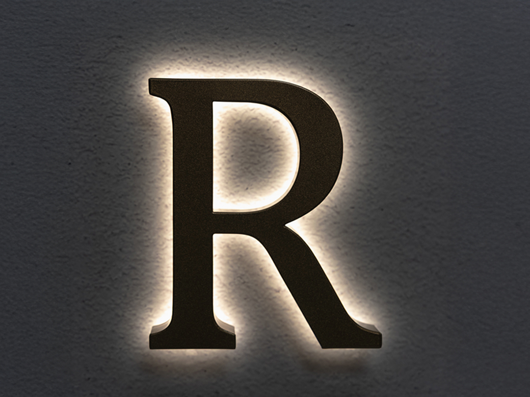 UH1 TruTrimless halo-lit channel letter with soft white backlight and aluminum finish.