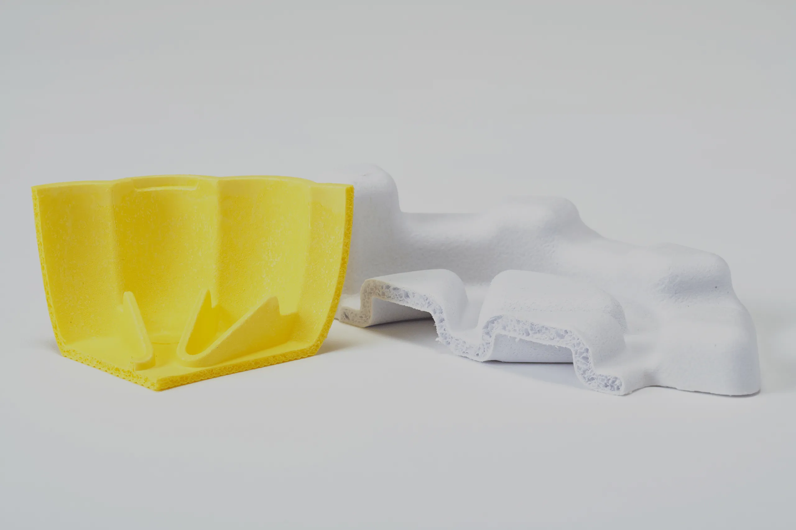 Eco-friendly molded fiber packaging prototypes in yellow and white, demonstrating sustainable material innovation and protective design by Nissha.