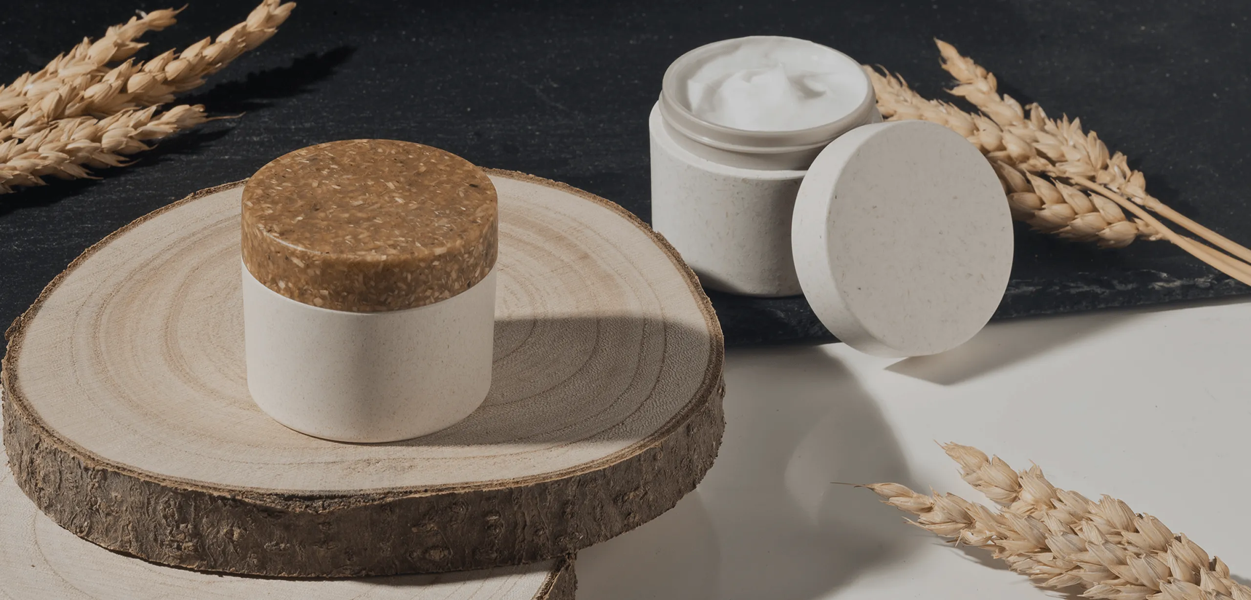 Sustainable cosmetic jars made from biodegradable materials with natural fiber lids, showcasing eco-friendly skincare packaging design on wooden surfaces.