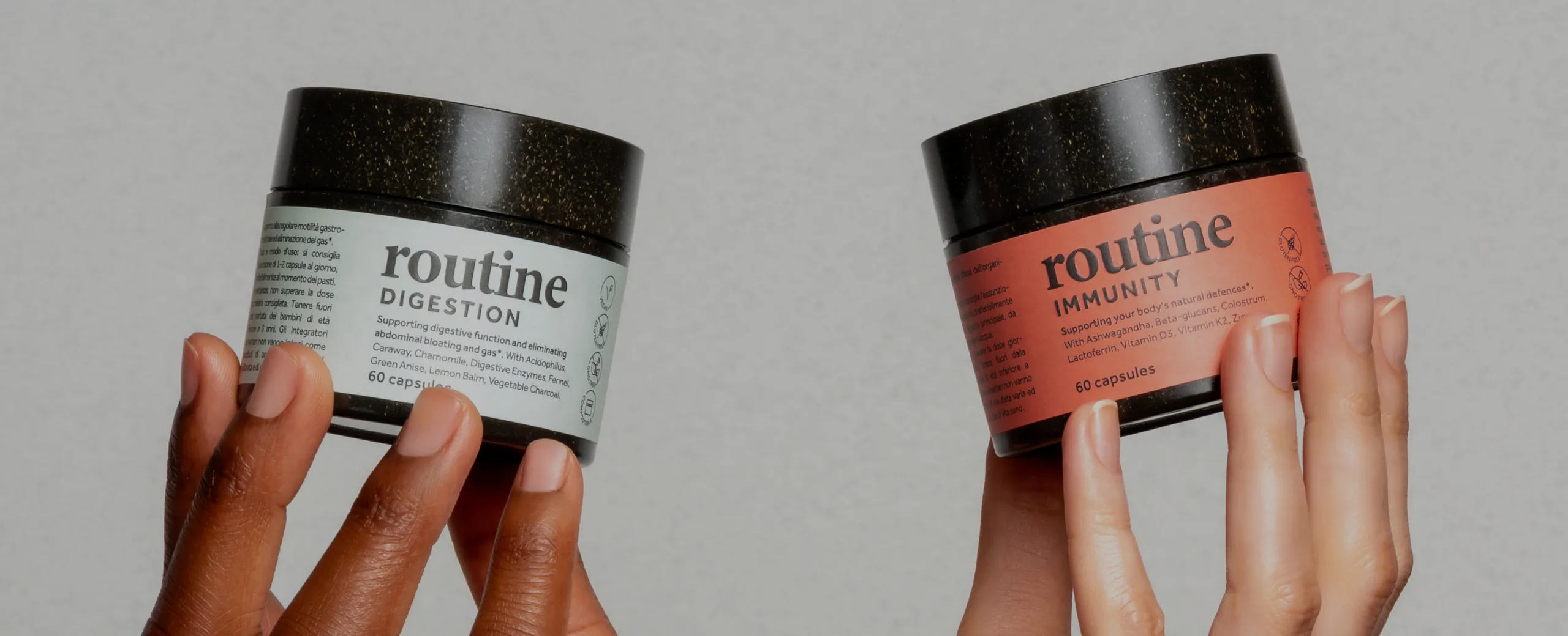 Hands holding eco-friendly supplement jars labeled Routine Digestion and Routine Immunity, showcasing sustainable packaging and modern wellness design.