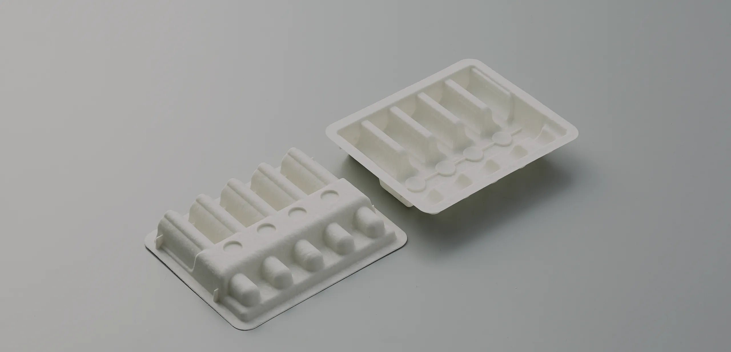 Eco-friendly molded fiber trays for ampoules or vials, showcasing sustainable biodegradable packaging solutions for pharmaceutical and cosmetic products.