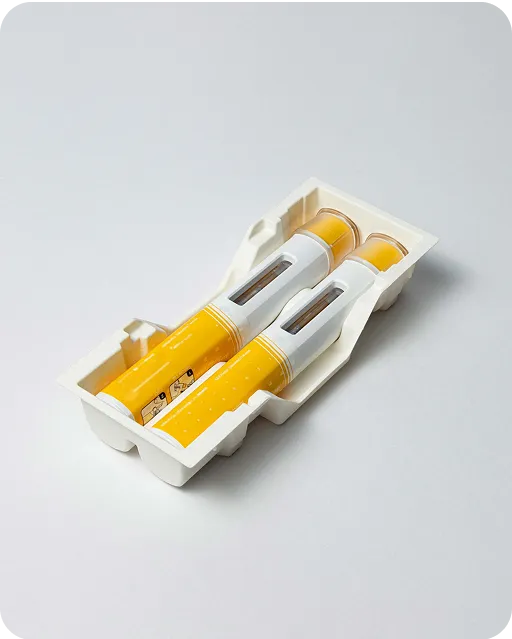 Eco-friendly molded fiber medical packaging holding two yellow injector pens, designed for sustainable and secure pharmaceutical storage.