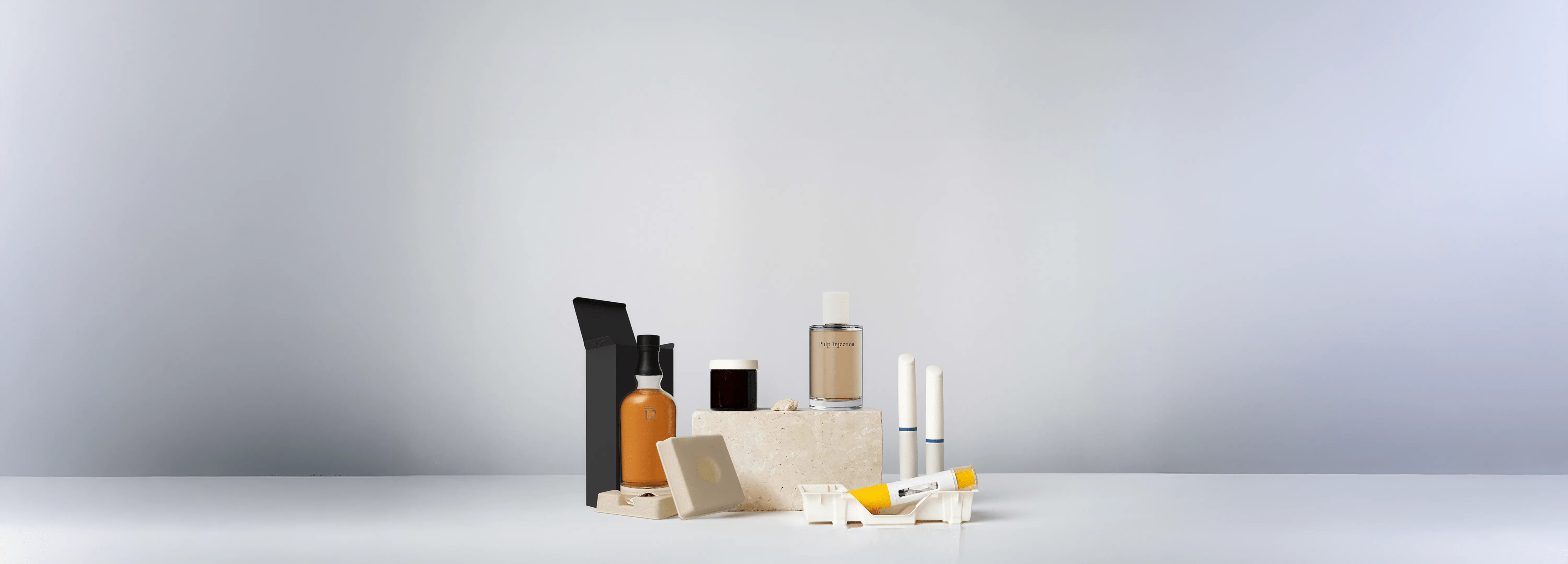 Premium sustainable packaging display featuring molded fiber inserts, cosmetic and perfume bottles, eco-friendly containers, and beverage packaging on a minimalist background.