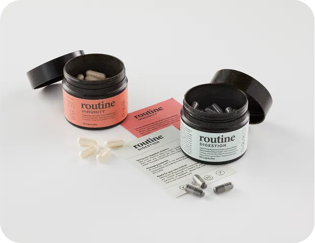 Eco-friendly supplement jars for immunity and digestion capsules from Routine, featuring sustainable black packaging and minimalist wellness product design.