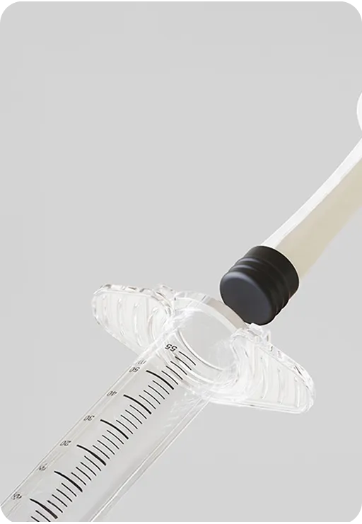 Close-up of a transparent medical syringe with measurement markings and black rubber stopper, representing precise and sterile healthcare equipment design.