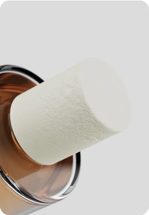 Eco-friendly molded fiber perfume cap on amber glass bottle, sustainable and minimalist fragrance packaging design.