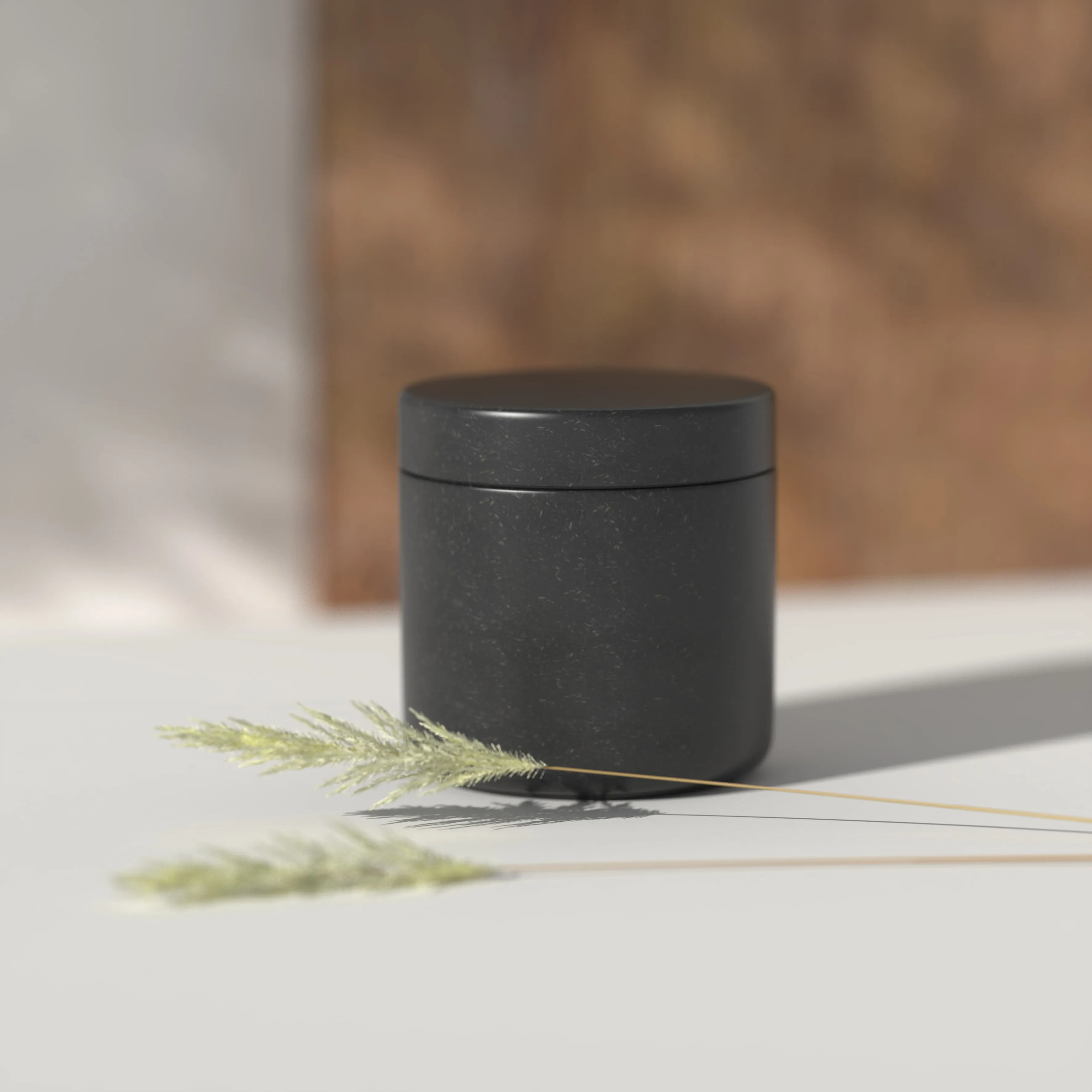 Black sustainable jar with natural fiber texture on a softly lit surface with a dried plant, representing eco-friendly minimalist cosmetic packaging.