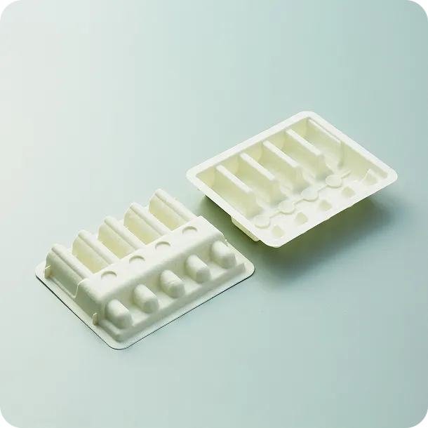 Stack of white biodegradable molded fiber trays with compartments, showcasing sustainable and eco-friendly packaging design.