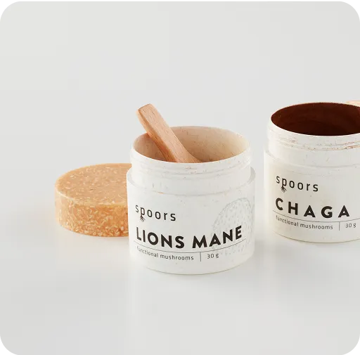 Eco-friendly Spoors jars containing Lions Mane and Chaga functional mushroom powder with biodegradable packaging and wooden spoon.