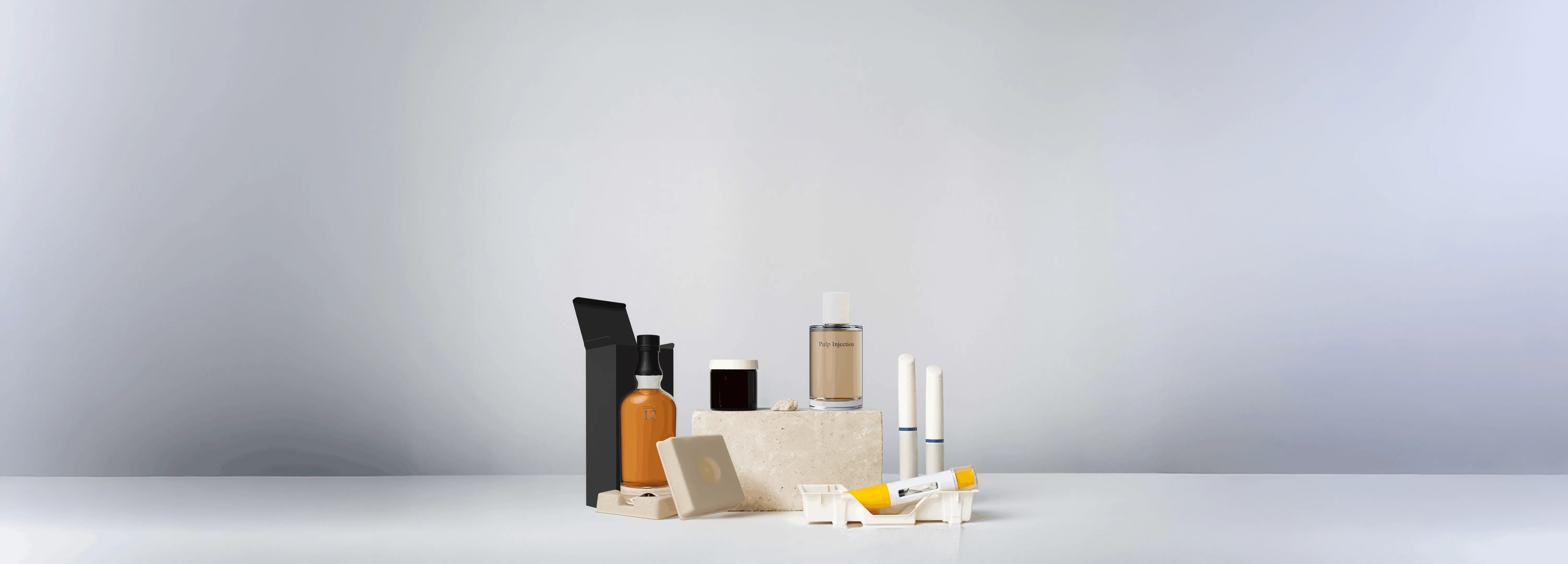 Assorted cosmetic and skincare bottles and containers arranged on a smooth surface with a plain light background.