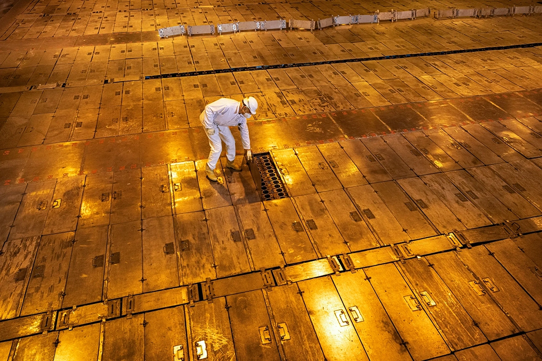 A worker inspects a spent fuel compartment in the cooling pool of an interim storage facility. © Gerd Ludwig, 2026