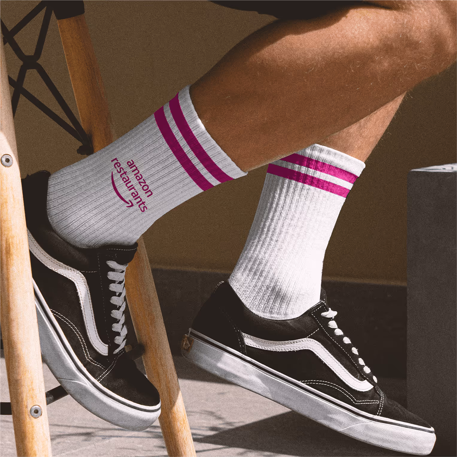 White athletic socks with magenta stripes and restaurants logo worn with sneakers.