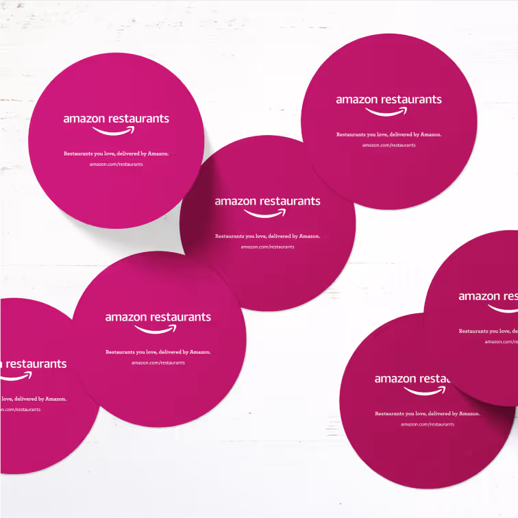 Six circular magenta branded coasters arranged on white surface.