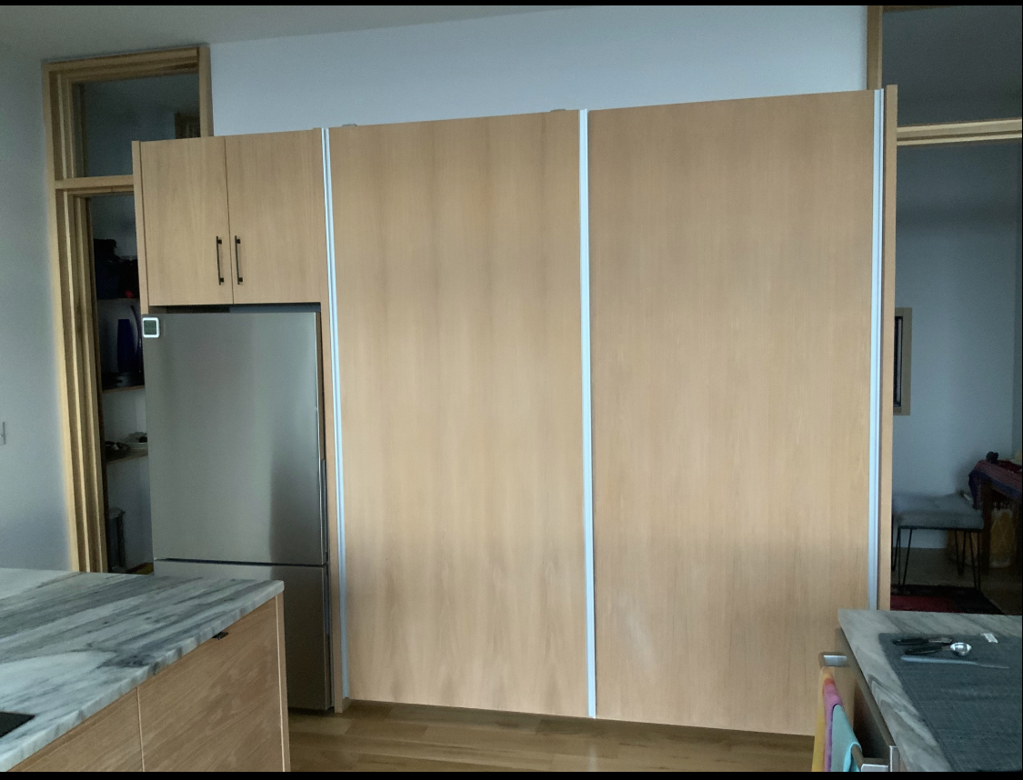 Custom Kitchen Pantry with Sliding Doors and Hidden Storage.