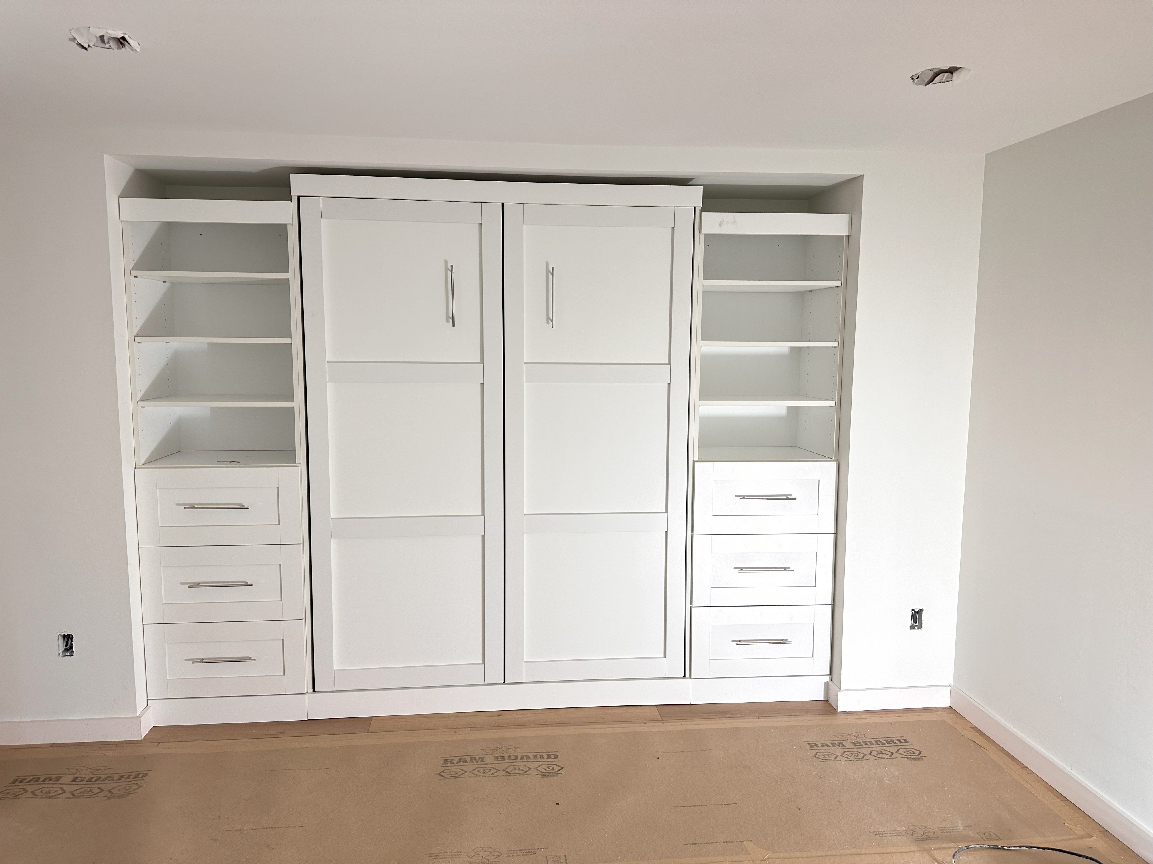 Custom folding bed with built-in cabinets and storage.