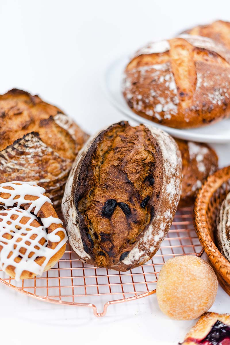 A plate of bread with a donut on the side.