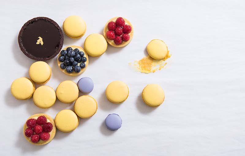 A white table with a variety of desserts on it.
