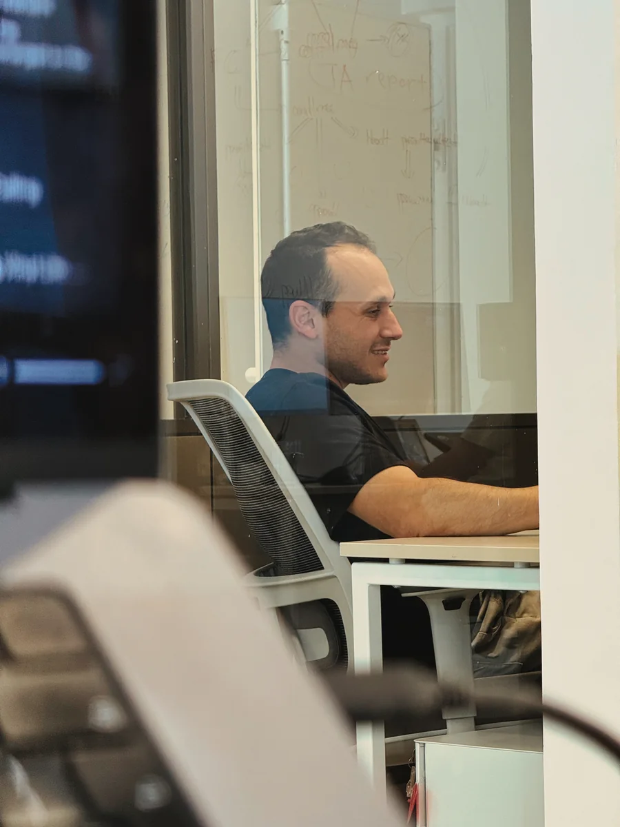 A Ballerine team member in a meeting room, seen through the glass