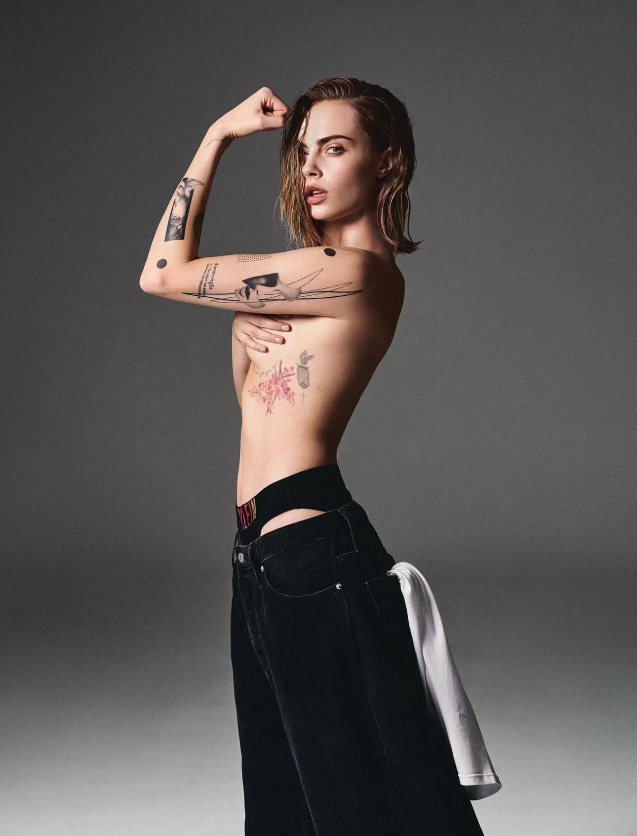 Tattoo-Künstler mit schwarzer Kappe und Brille tätowiert ein Bein in einem modernen Studio.