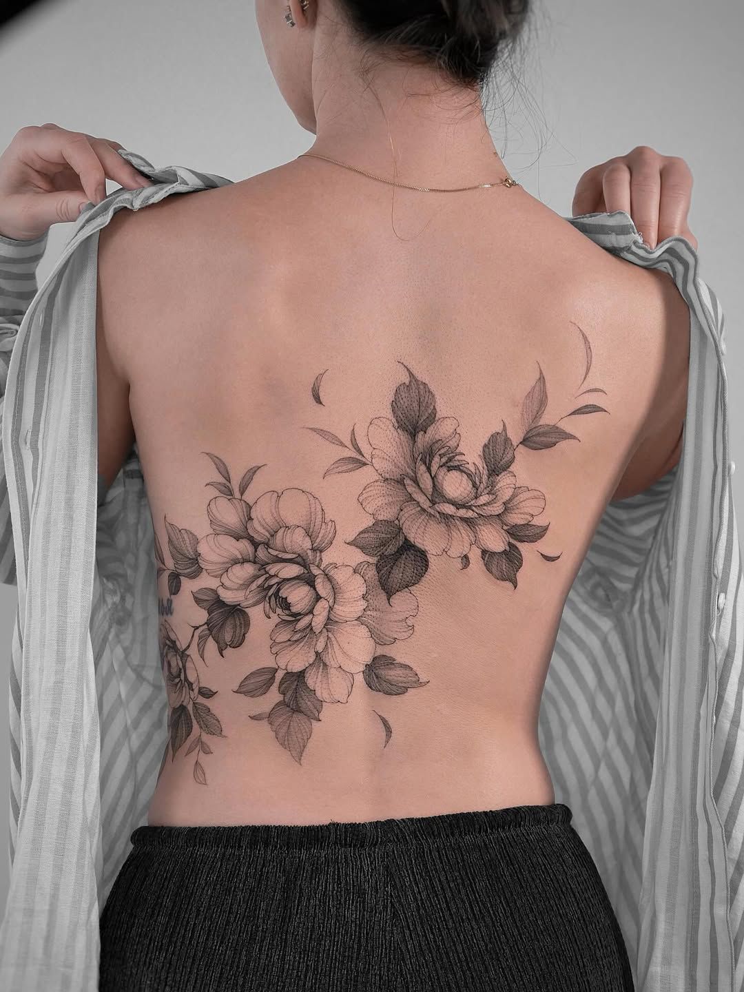 Tattoo eines LEGO-Männchens, das einen Luftballon in Form der Erde hält, mit dem Mond in der Nähe auf einem Unterarm.