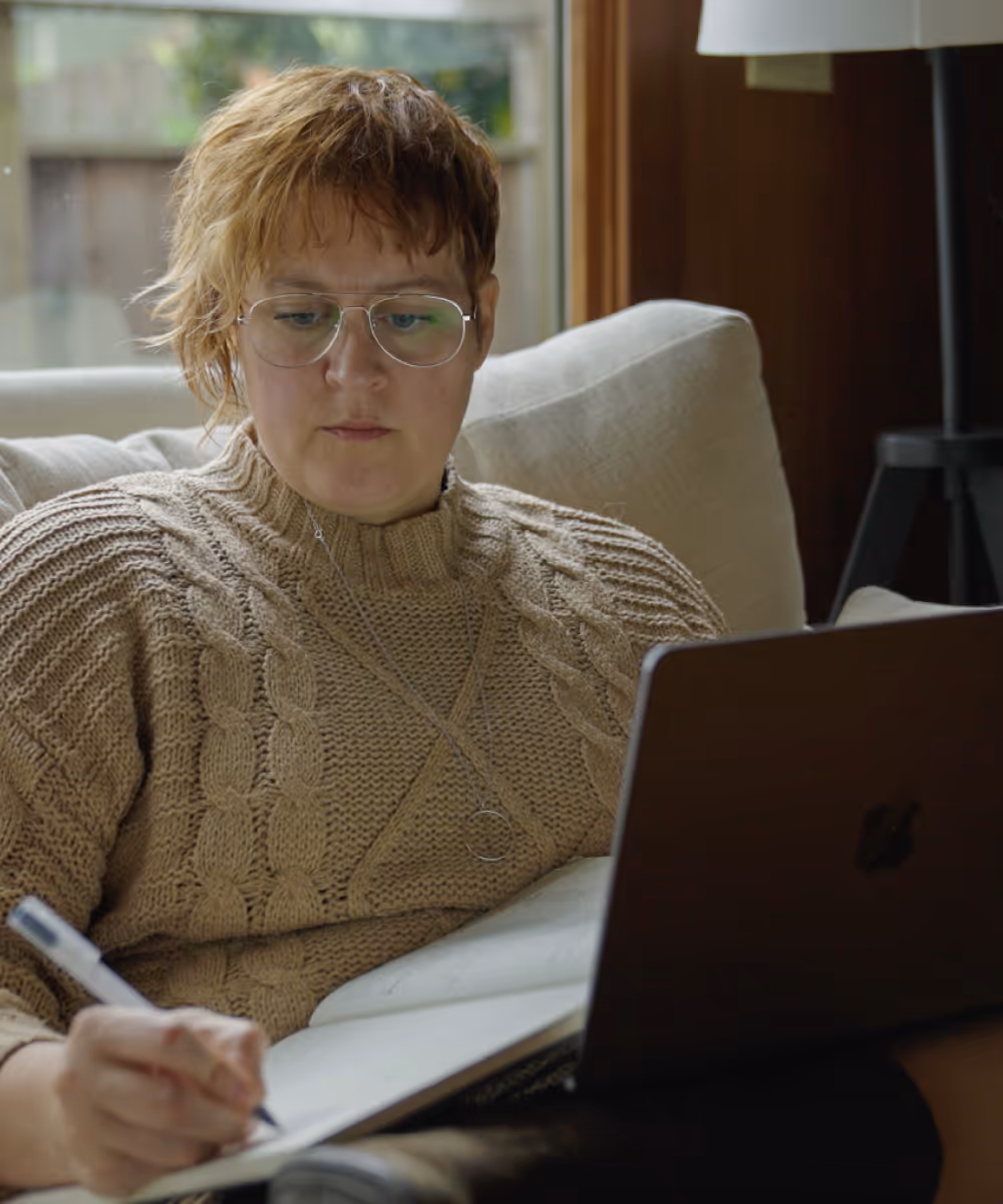 Danielle, Founder of Applestone Consulting, taking notes and working out of her laptop.