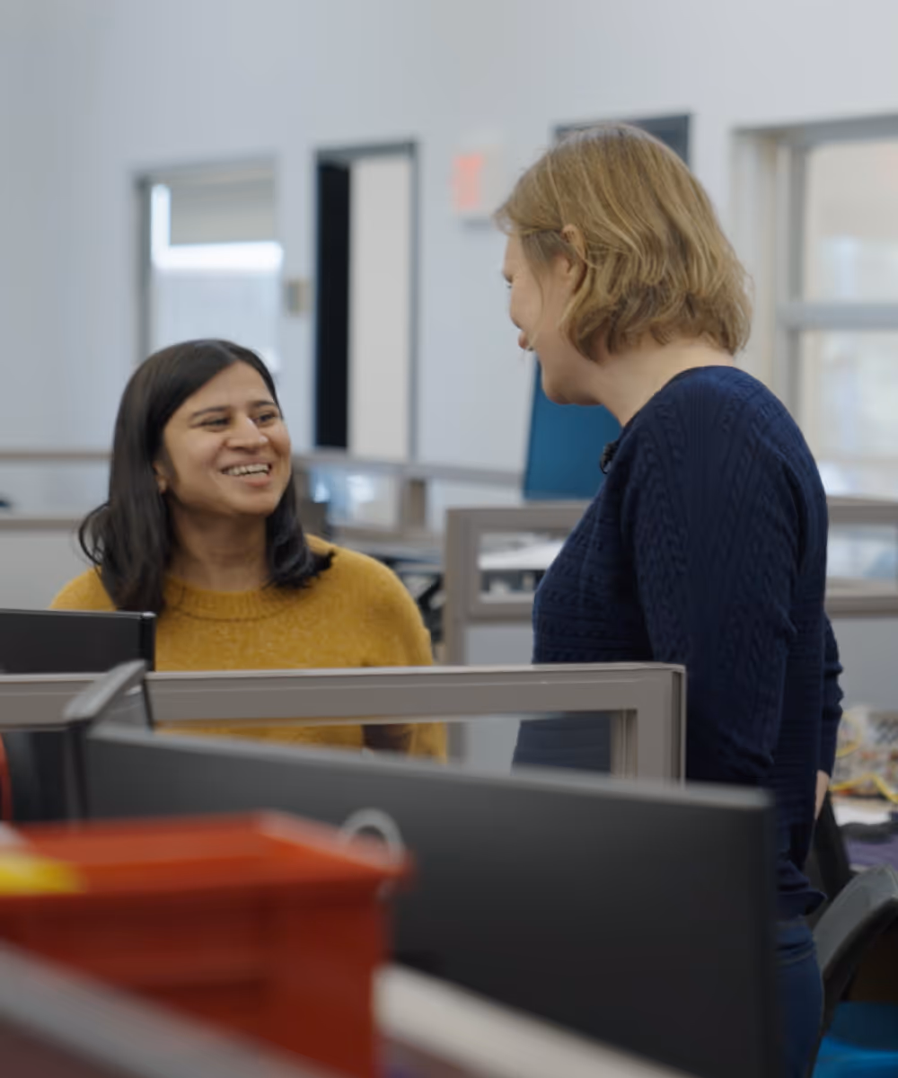 A CEO having a lighthearted conversation with an employee in their office.