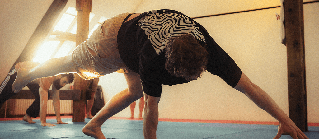 Teilnehmende beim Movement Training im Bewegungskollektiv Berlin erkunden durch fließende Bodenbewegungen Kraft und Balance.