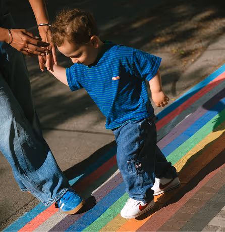 a child walking on a rainbow flag
