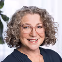 a woman with curly hair wearing glasses