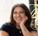 a woman smiling with her hand on her chin