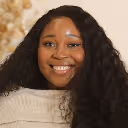 a woman with long curly hair smiling