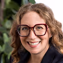 a woman wearing glasses smiling
