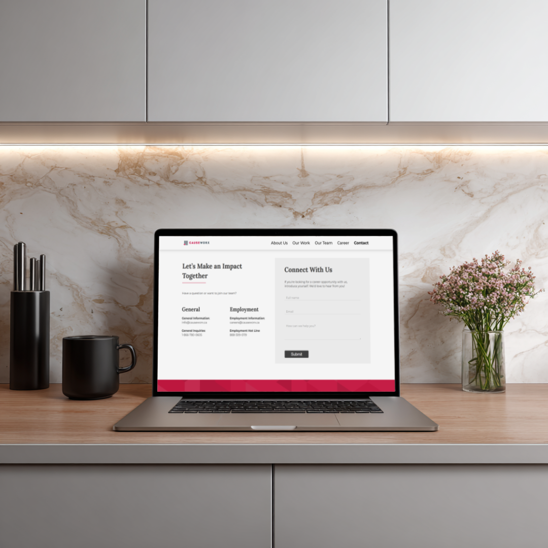 Laptop showing Causeworx contact page on a marble kitchen counter with flowers and coffee mug