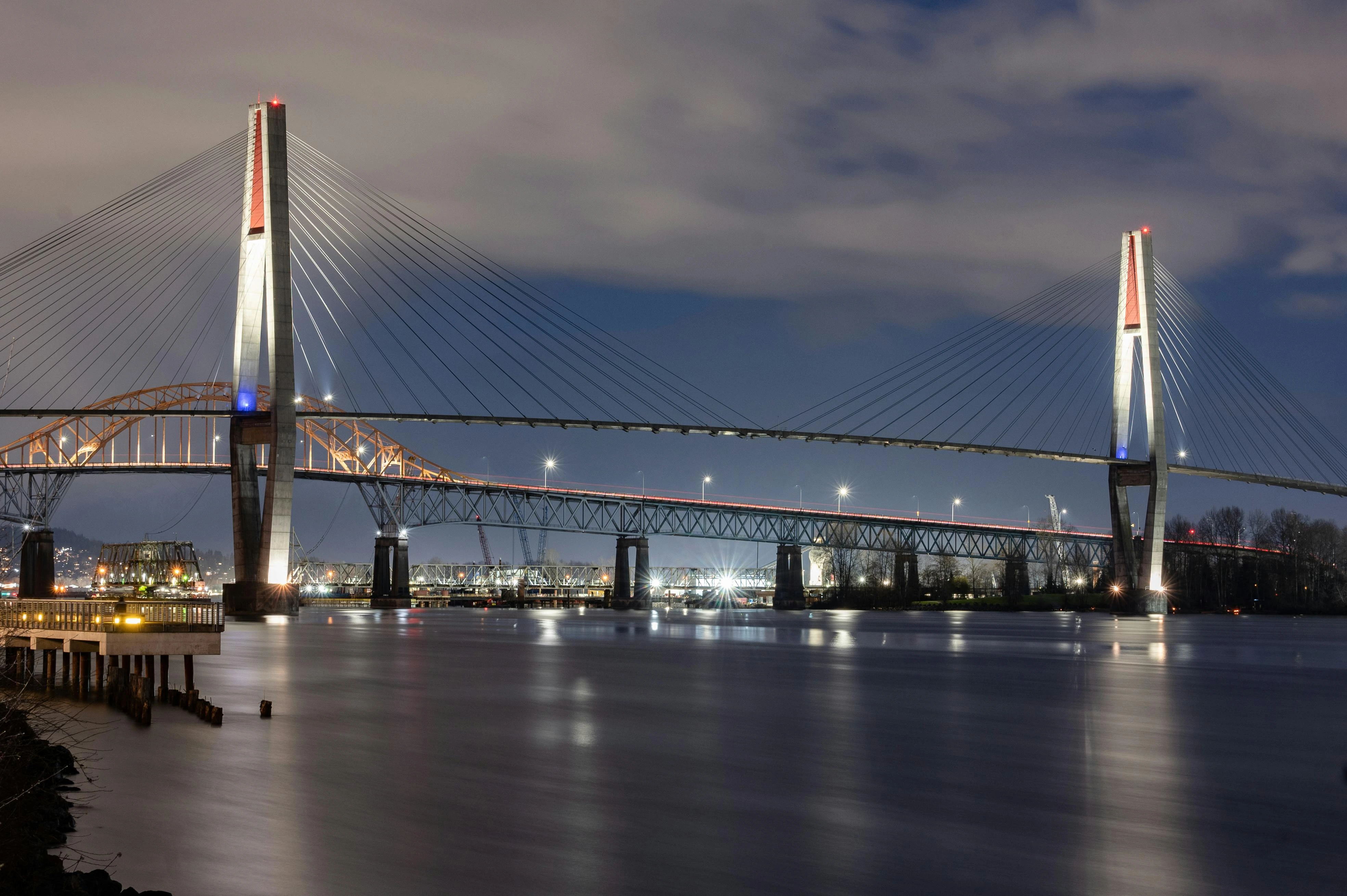 Long exposure night photography of the Skybridge crossing the Fraser River between New Westminster and Surrey, BC.
