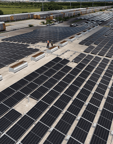 Ingenieros de Energía Real supervisando instalación de paneles solares a gran escala en planta automotriz industrial en México